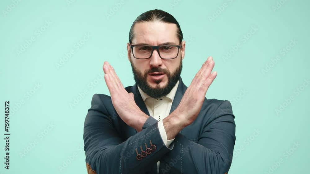 A man in a tailored blue suit and glasses firmly crosses his arms, displaying a clear gesture of disagreement or denial against a light turquoise backdrop. Camera 8K RAW.
