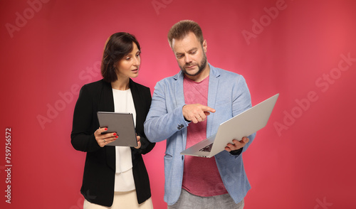 two business people approve recommend using a tablet laptop on a color background isolated © serhii