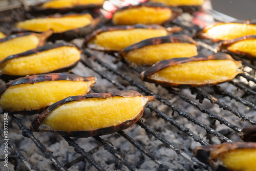 Bananas are being grilled on a charcoal grill. Let it cook slowly, street food in Thailand, Grilled bananas are a sweet and delicious dessert