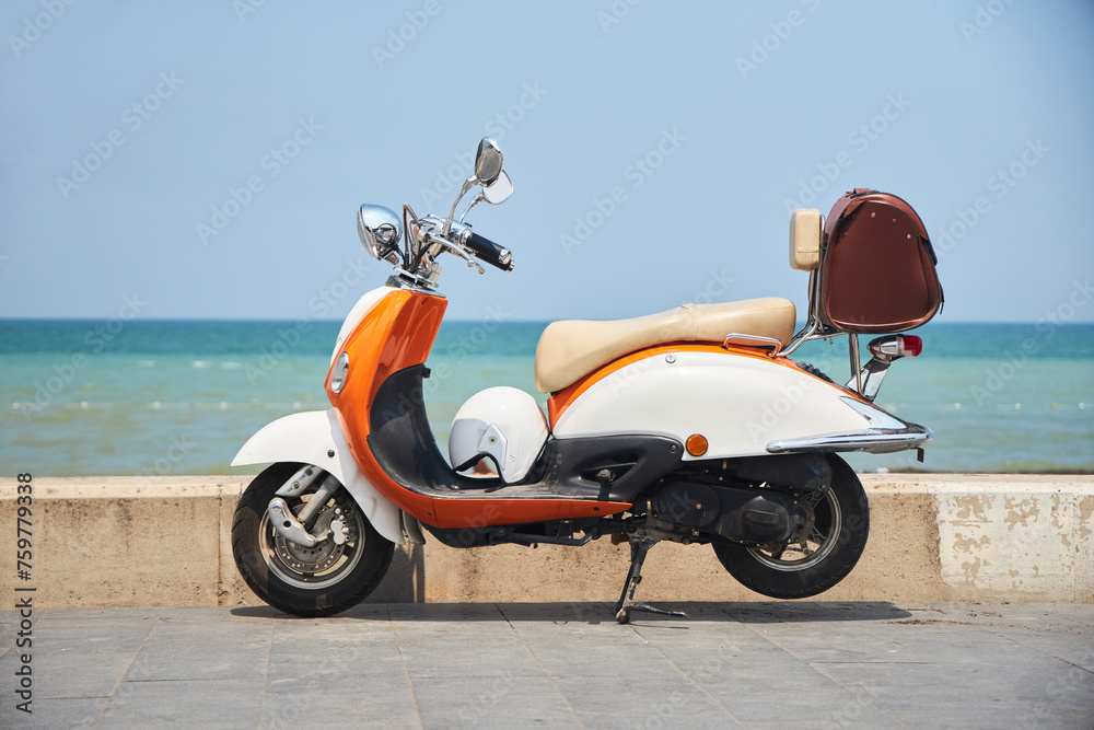 An old vintage scooter on the beach by the sea. Transport for city trips