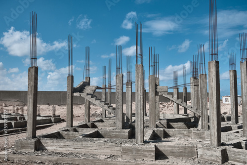 Reinforced concrete frame at construction site. Concrete pillars and staircases of unfinished residential building © Philipp Berezhnoy