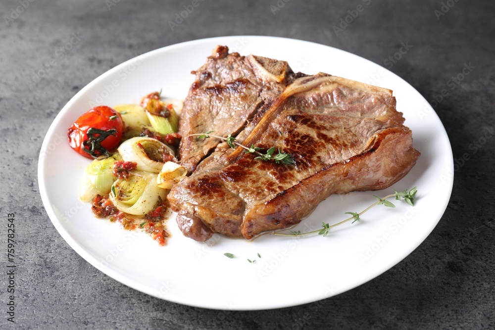Delicious fried beef meat and vegetables on grey table Delicious fried beef meat and vegetables on grey table