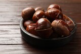 Roasted edible sweet chestnuts on wooden table, closeup