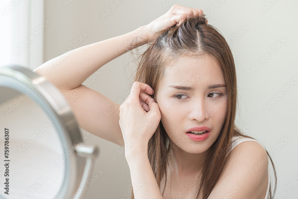 Damaged hair symptom, problem hair fall asian young woman, girl worry about balding, looking at scalp in mirror, hand in break into front hair loss, thin problem. Health care treatment for beauty. Damaged hair symptom, problem hair fall asian young woman, girl worry about balding, looking at scalp in mirror, hand in break into front hair loss, thin problem. Health care treatment for beauty.