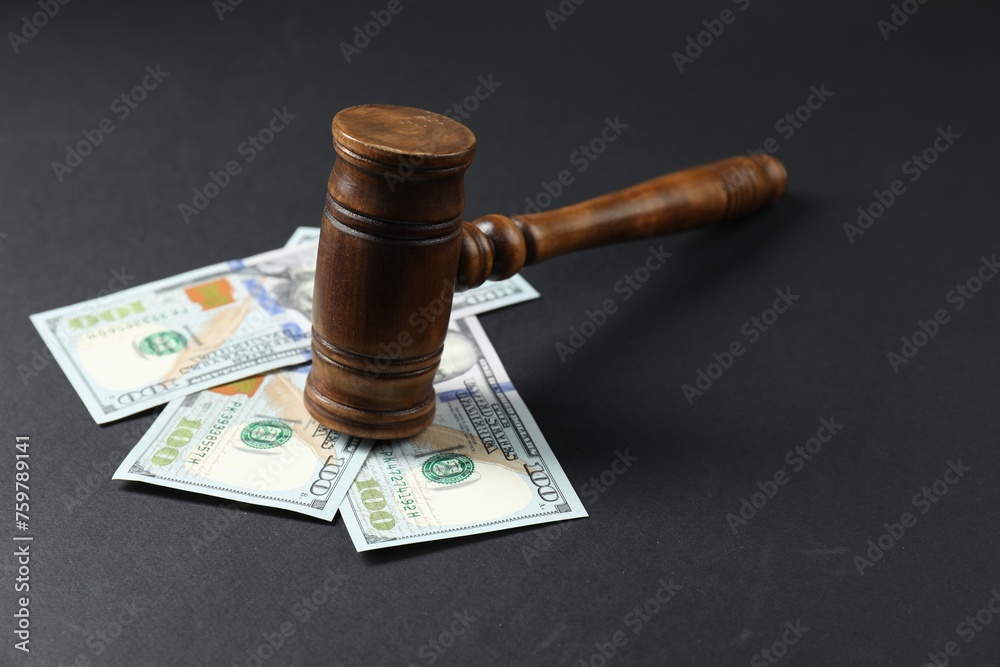 Law gavel with dollars on grey table