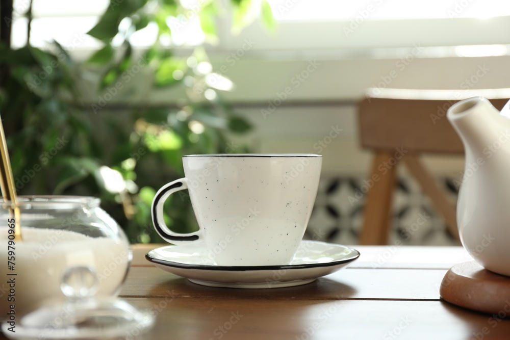 Fototapeta premium Cup of aromatic tea and sugar on wooden table indoors