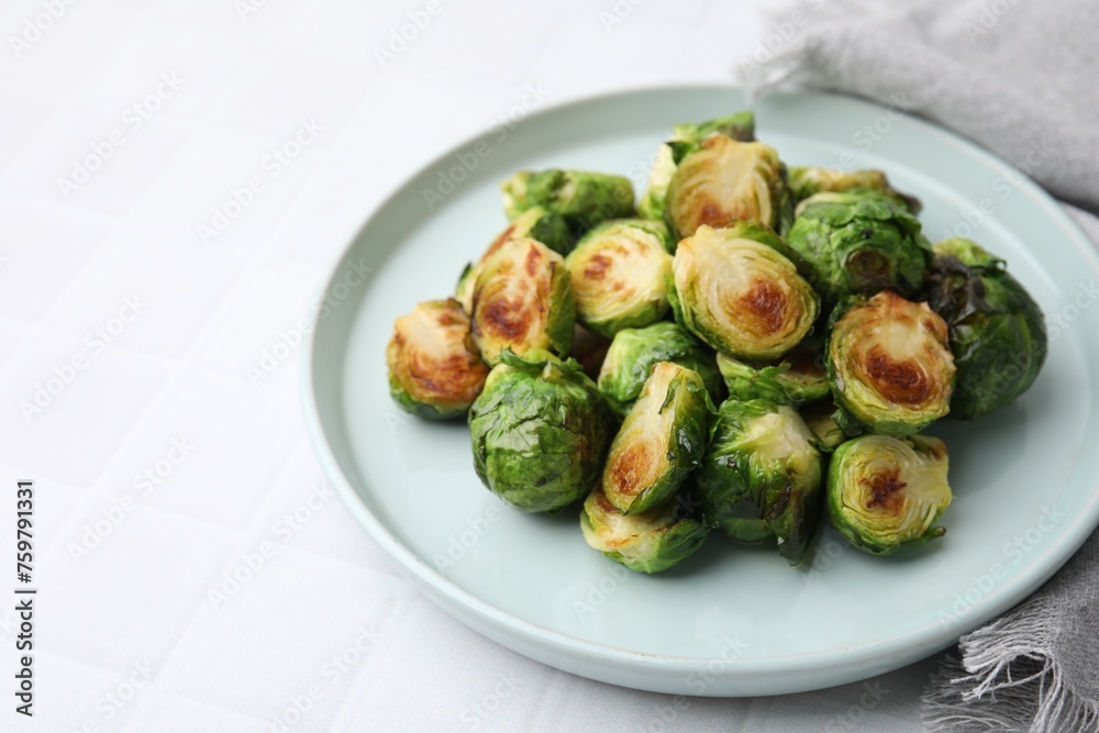 Delicious roasted Brussels sprouts on white tiled table, space for text Delicious roasted Brussels sprouts on white tiled table, space for text