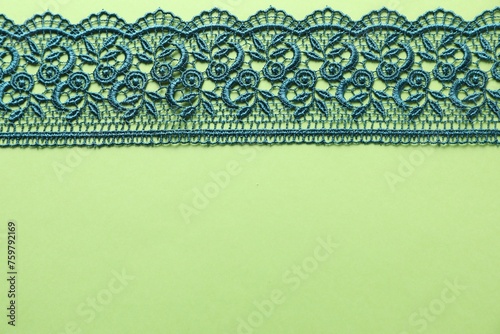 Beautiful lace on green background, top view. Space for text