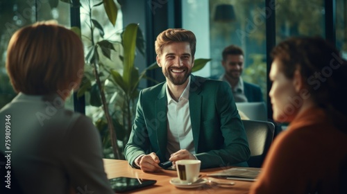 A group of Happy, Satisfied, Successful Businessmen at a coffee table meeting. Young Men and Women laugh, Discuss Ideas, and Plan to launch Projects in the Office.