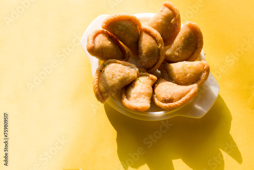 Gujia or Gujiya is a traditional Indian sweet or dessert made during Holi ,Diwali Festival.Resembles Spanish Empanada is deep fried or baked.Made from floor,milk solids,sugar,raisins,semolina.Closeup. photo