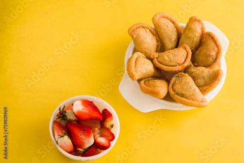 Gujia or Gujiya is a traditional Indian sweet or dessert made during Holi ,Diwali Festival.Resembles Spanish Empanada is deep fried or baked.Made from floor,milk solids,sugar,raisins,semolina.Closeup. photo