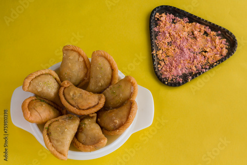 Gujia or Gujiya is a traditional Indian sweet or dessert made during Holi ,Diwali Festival.Resembles Spanish Empanada is deep fried or baked.Made from floor,milk solids,sugar,raisins,semolina.Closeup. photo