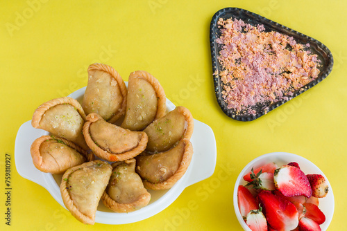 Gujia or Gujiya is a traditional Indian sweet or dessert made during Holi ,Diwali Festival.Resembles Spanish Empanada is deep fried or baked.Made from floor,milk solids,sugar,raisins,semolina.Closeup. photo