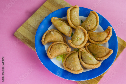 Gujia or Gujiya is a traditional Indian sweet or dessert made during Holi ,Diwali Festival.Resembles Spanish Empanada is deep fried or baked.Made from floor,milk solids,sugar,raisins,semolina.Closeup. photo
