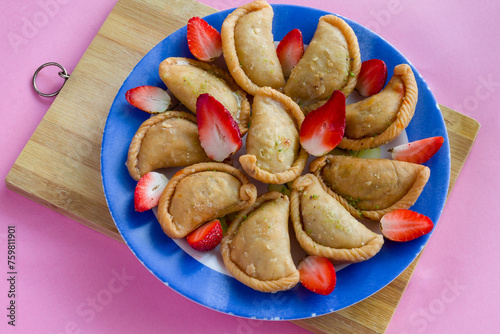 Gujia or Gujiya is a traditional Indian sweet or dessert made during Holi ,Diwali Festival.Resembles Spanish Empanada is deep fried or baked.Made from floor,milk solids,sugar,raisins,semolina.Closeup. photo