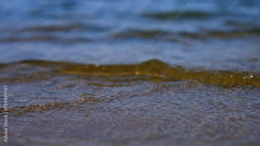 Slow waves come up to the sandy shore. Close up view on the river bank on sunny day. Slow waves come up to the sandy shore. Close up view on the river bank on sunny day.
