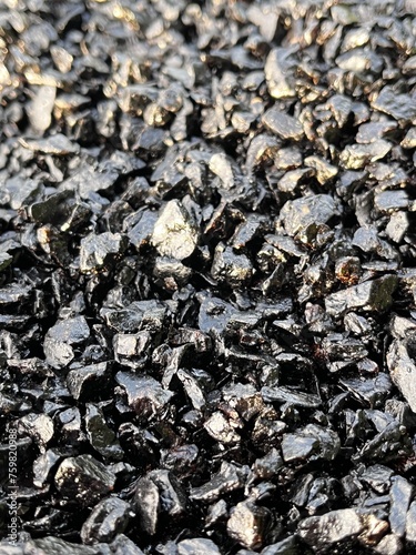 Black textured rough stone rock asphalt road close up photo picture. Rough rugged harsh stiff sticky surface hard tarmac dark color