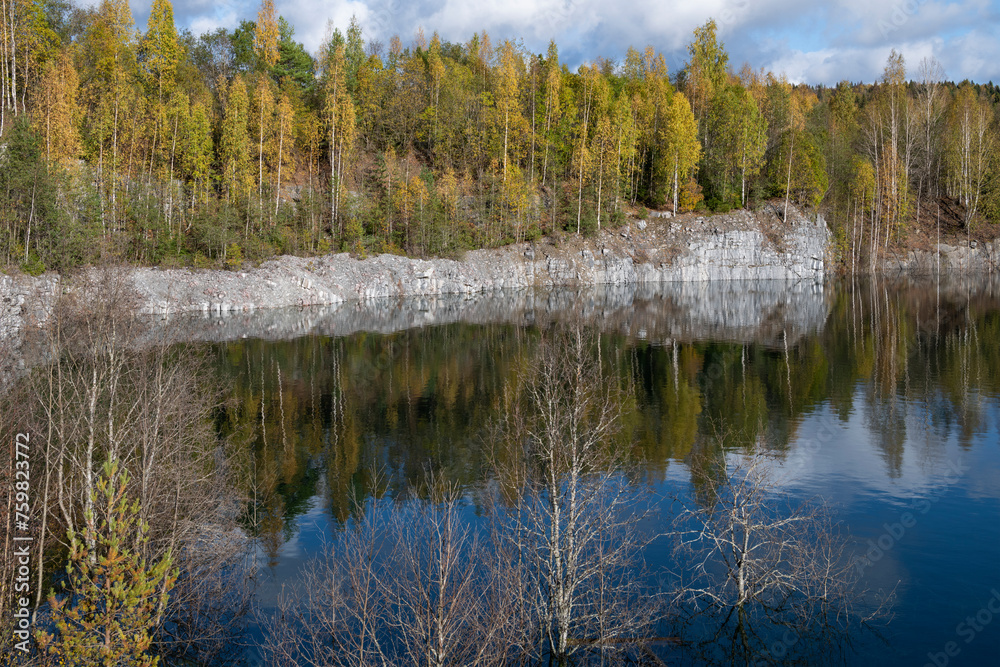 Old flooded marble quarry on a golden autumn. Ruskeala, Karelia. Russia Old flooded marble quarry on a golden autumn. Ruskeala, Karelia. Russia