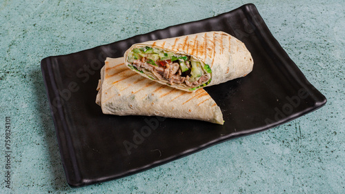 Cuadro en lienzo Sliced durum kebab on black tray top view