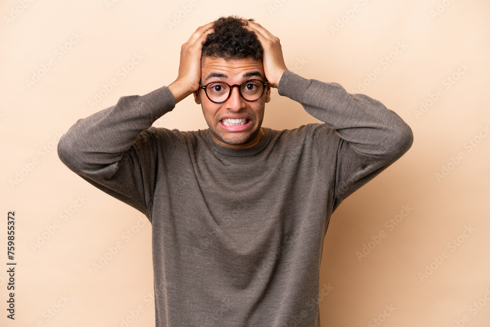 Young Brazilian man isolated on beige background doing nervous gesture Young Brazilian man isolated on beige background doing nervous gesture