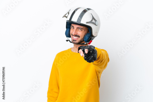 Young caucasian man with a motorcycle helmet isolated on white background pointing front with happy expression
