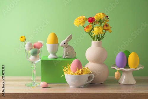 Easter holiday modern composition with flowers bouquet and Easter eggs decoration on wooden table over green background