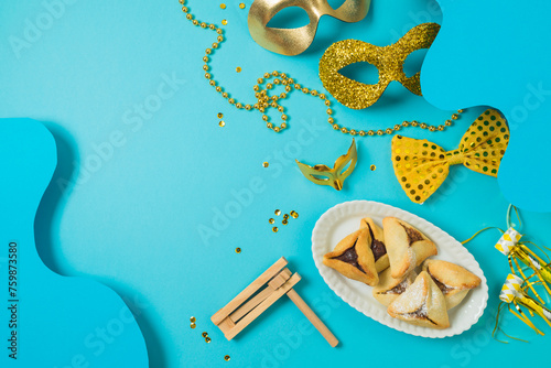Jewish holiday Purim background with carnival mask and hamantaschen cookies. Top view, flat lay  composition