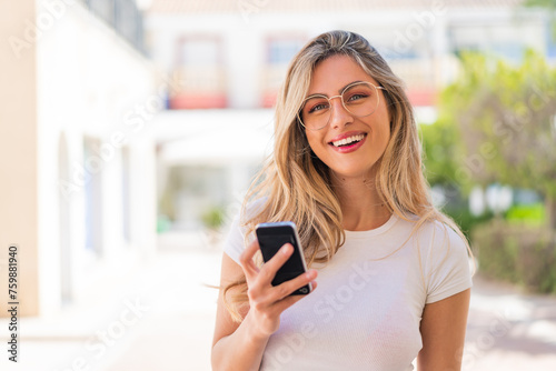 Pretty blonde Uruguayan woman using mobile phone