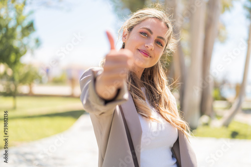 Young pretty blonde Uruguayan woman at outdoors with thumbs up because something good has happened © luismolinero