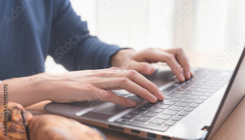 A person is typing on a laptop keyboard