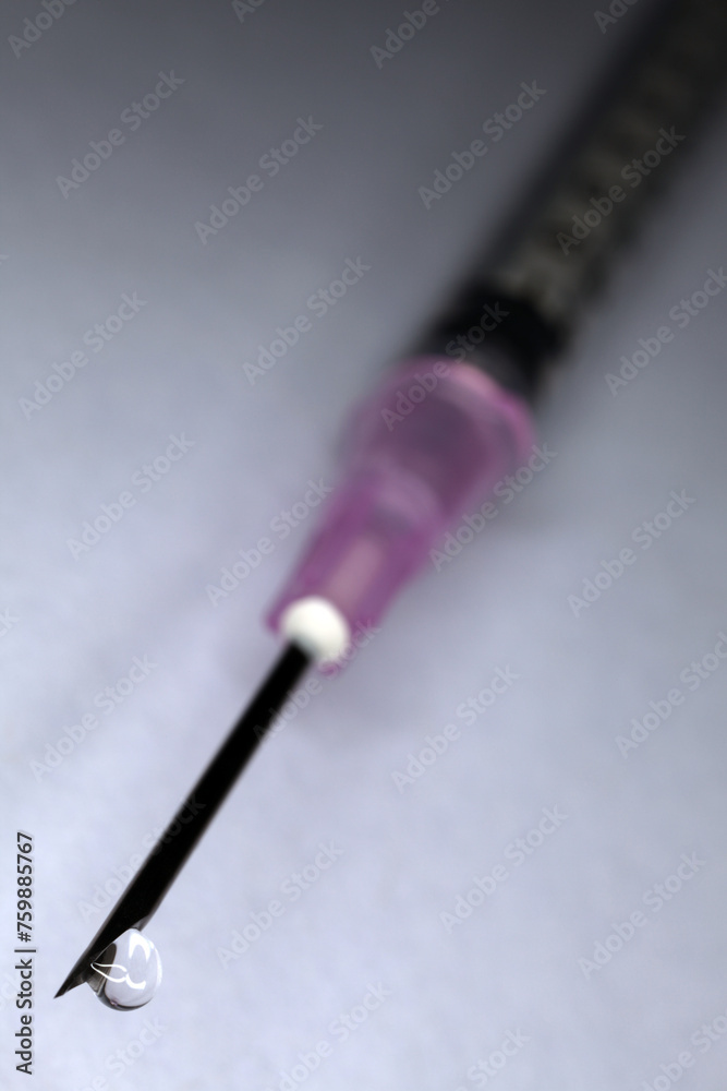Naklejka premium Syringe and needle with drop of clear liquid