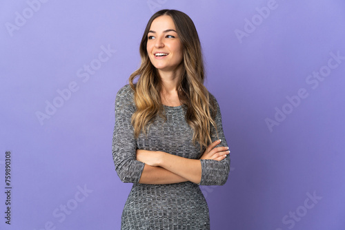 Young Romanian woman isolated on purple background happy and smiling