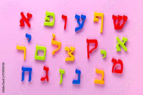  Fridge magnet Hebrew alphabet spelling letters over pink background.