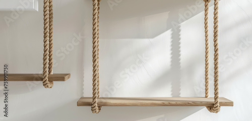 Minimalist Wooden Wall Ladder. Close-up of minimalist wall ladder with wooden rungs secured by rope, sports complex for children's room, copy space. photo