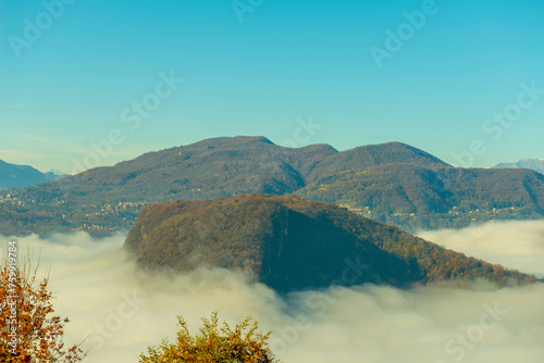 Mountain Range on the Border to Italy on Lake Lugano with Cloudscape and Sunlight on a Clear Sky in Caslano, Ticino in Switzerland. photo