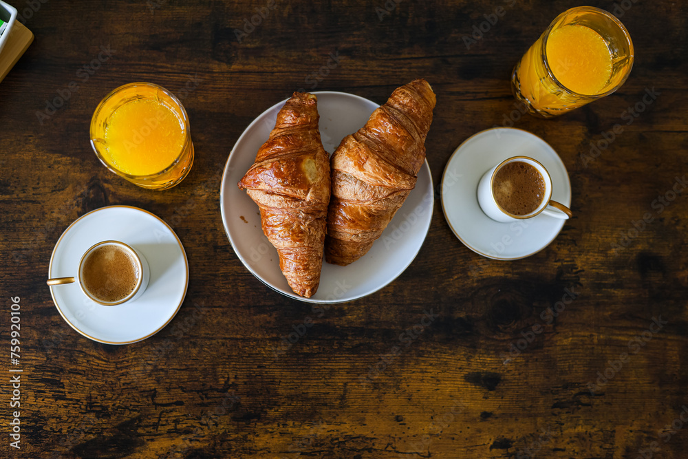 Cozy breakfast in the morning. Close up photo with orange juice, French croissants, coffee and milk or sugar on the site. Homemade breakfast.