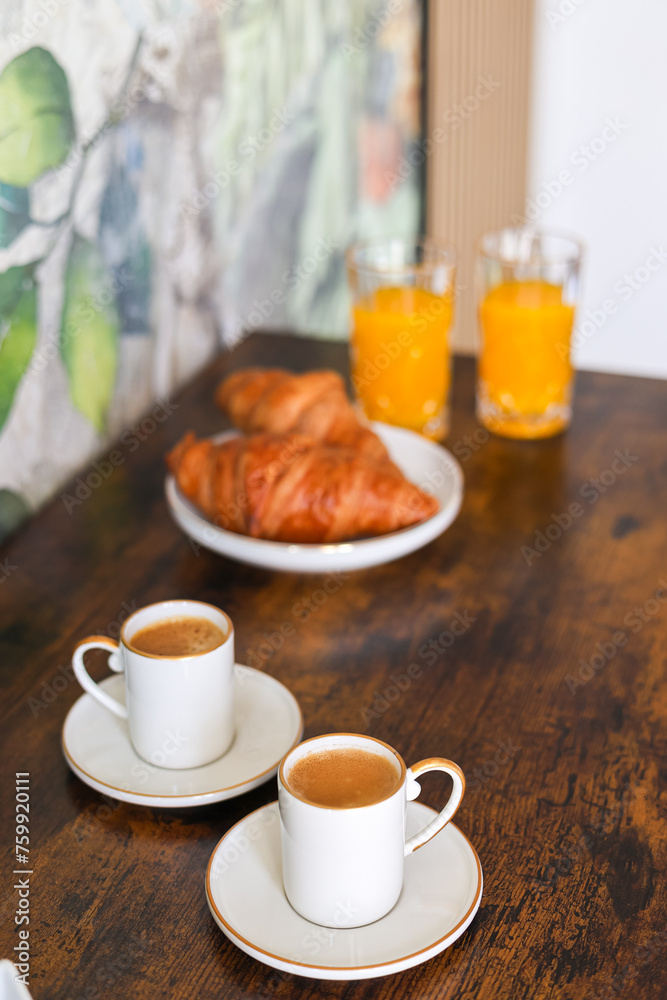 Cozy breakfast in the morning. Close up photo with orange juice, French croissants, coffee and milk or sugar on the site. Homemade breakfast.