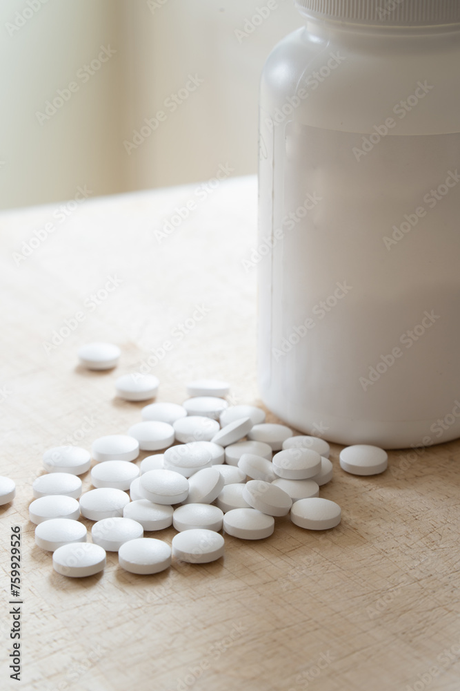 Plastic medicine bottle and white capsule pills out, medicine and health concept Plastic medicine bottle and white capsule pills out, medicine and health concept