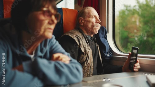 An elderly couple travels by train, Slow motion. An old husband and wife are traveling on a train. photo