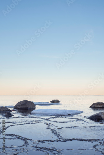 Rocks and ice in the freezing calm sea in the morning