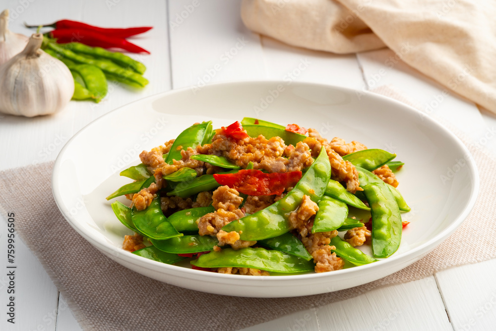 Stir fried snow peas with minced pork in white plate.Thai style food.