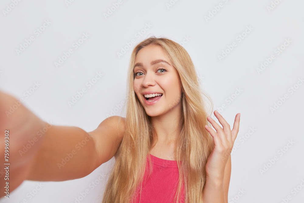 Beautiful girl taking selfie over background, long golden hair and blue eyes with cute smile, happy life concept, copy space Beautiful girl taking selfie over background, long golden hair and blue eyes with cute smile, happy life concept, copy space