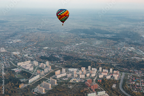 Colorful Hot Air Balloon Floating Over Urban Landscape at Dusk