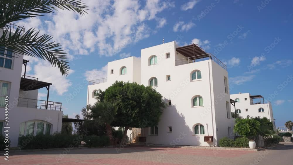 Mediterranean style villas line upscale beach resort. Luxury homes, palm trees, clear skies, holiday retreat for affluent travelers. Mediterranean style villas line upscale beach resort. Luxury homes, palm trees, clear skies, holiday retreat for affluent travelers.