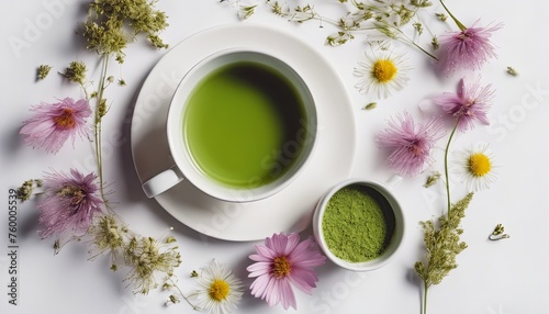 Flat lay photograph of wildflowers on a white background and a cup of matcha tea in the center.