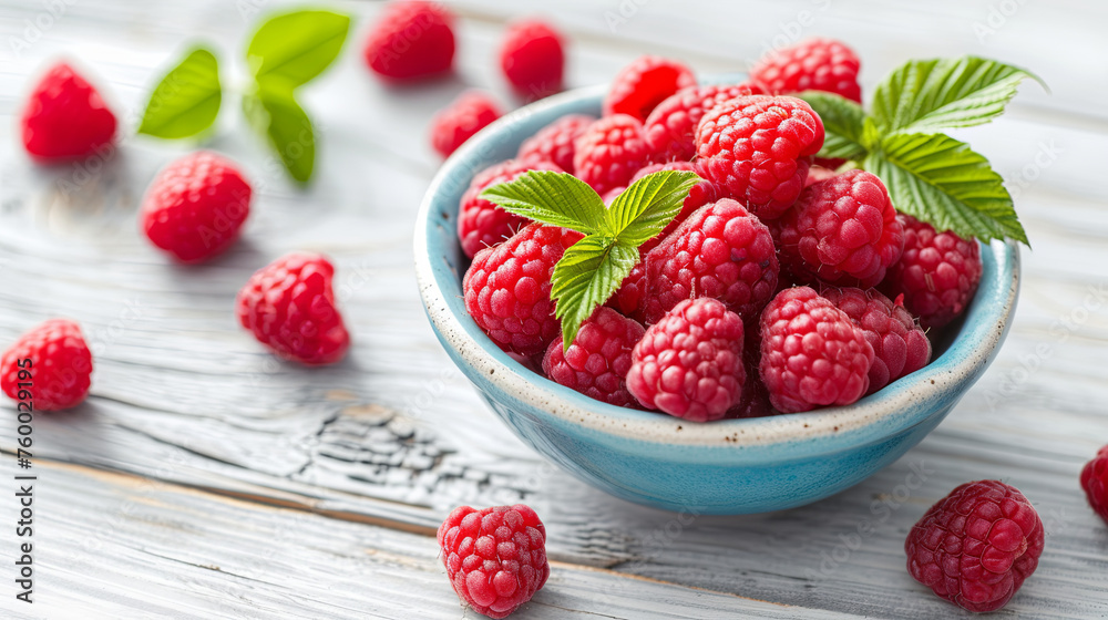 A handful of delicious juicy raspberries in a plate on a wooden light background A handful of delicious juicy raspberries in a plate on a wooden light background