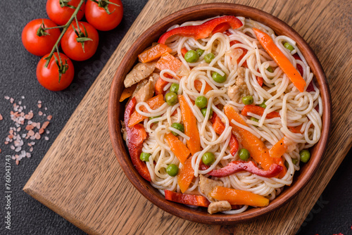 Delicious rice noodles or udon with chicken, carrots, pepper, salt, spices and herbs