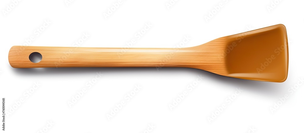 A wooden spatula, a kitchen utensil, with a hole in the handle for easy hanging. Made of hardwood with a wood stain and varnish finish, displayed on a white background A wooden spatula, a kitchen utensil, with a hole in the handle for easy hanging. Made of hardwood with a wood stain and varnish finish, displayed on a white background