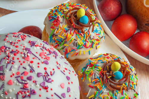 Traditional paska with sprinkles and colored eggs. Nest with yellow-blue eggs, close-up photo