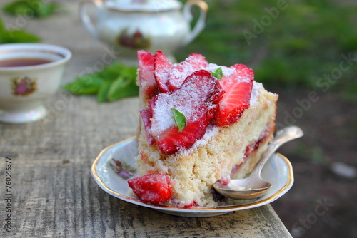 Piece of Strawberry pie on a plate served on a wooden table with green grass background. Summer homemade cakes with fresh berries. Family breakfast. Slow living concept © Foodie Studio